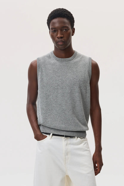 Male model wearing Johnstons of Elgin SS25 Unisex Knitwear Light Grey Cashmere Tank and white trousers  KAP05243HA0308