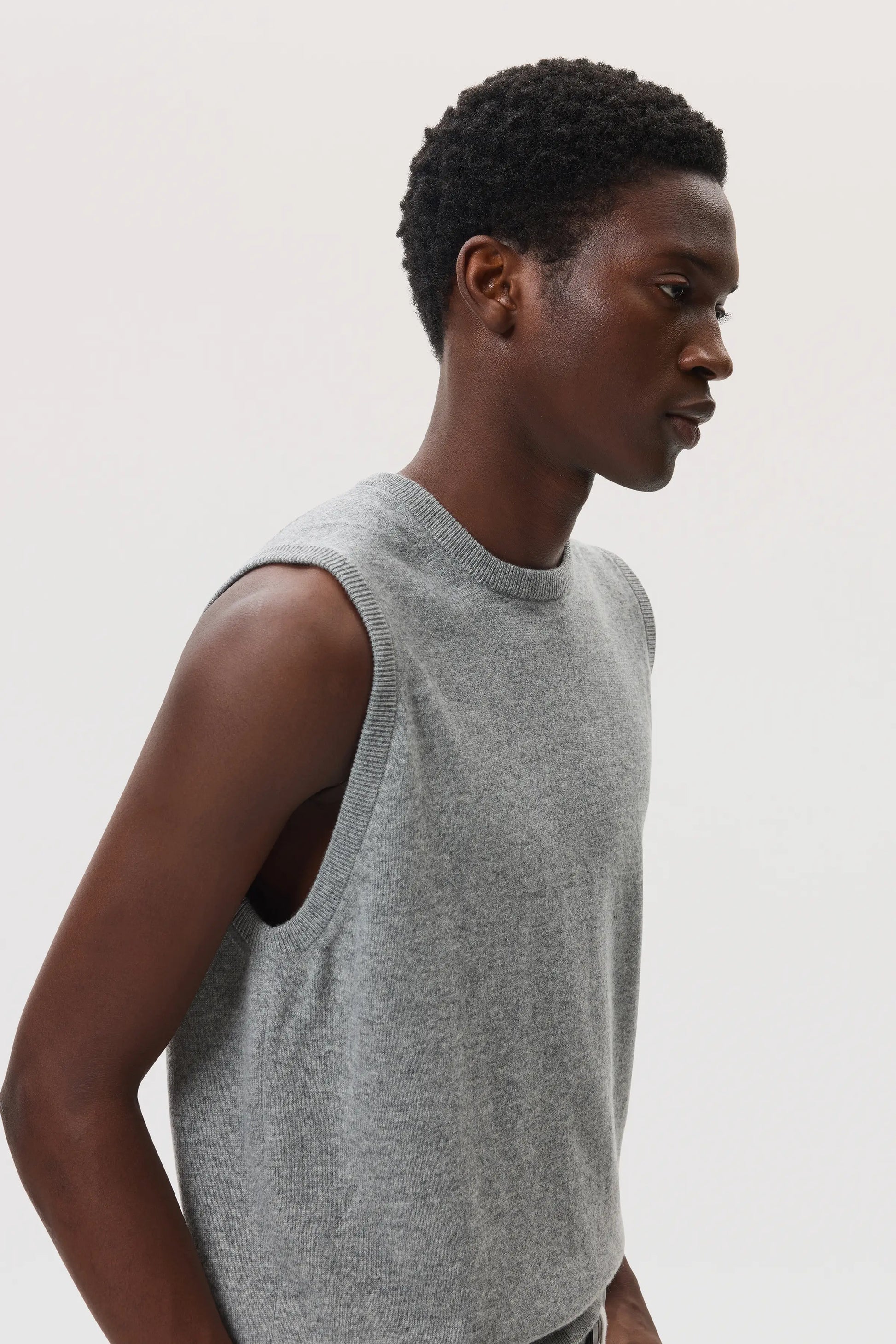 Male model wearing Johnstons of Elgin SS25 Unisex Knitwear Light Grey Cashmere Tank against a white background  KAP05243HA0308