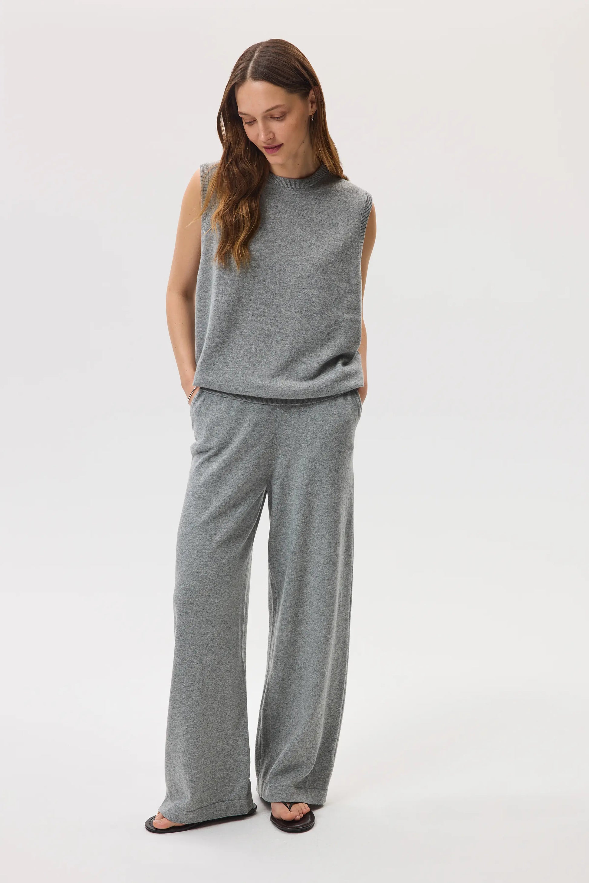 Female model wearing Johnstons of Elgin SS25 Unisex Knitwear Light Grey Cashmere Tank and matching cashmere culottes against a white background  KAP05243HA0308