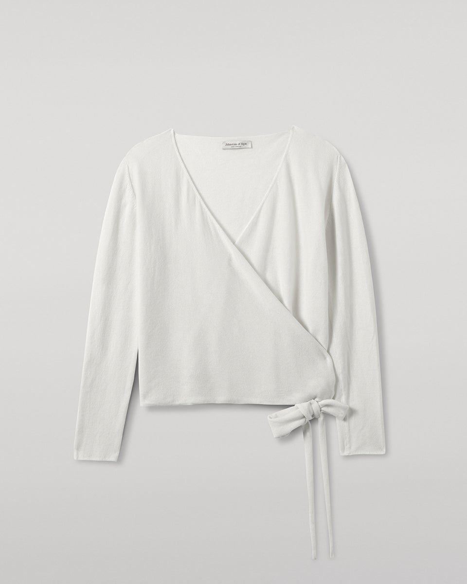 Johnstons of Elgin AW25 Women's Knitwear White Featherlight Cashmere Ballet Wrap with white trousers on a light background KAP05408HA0346