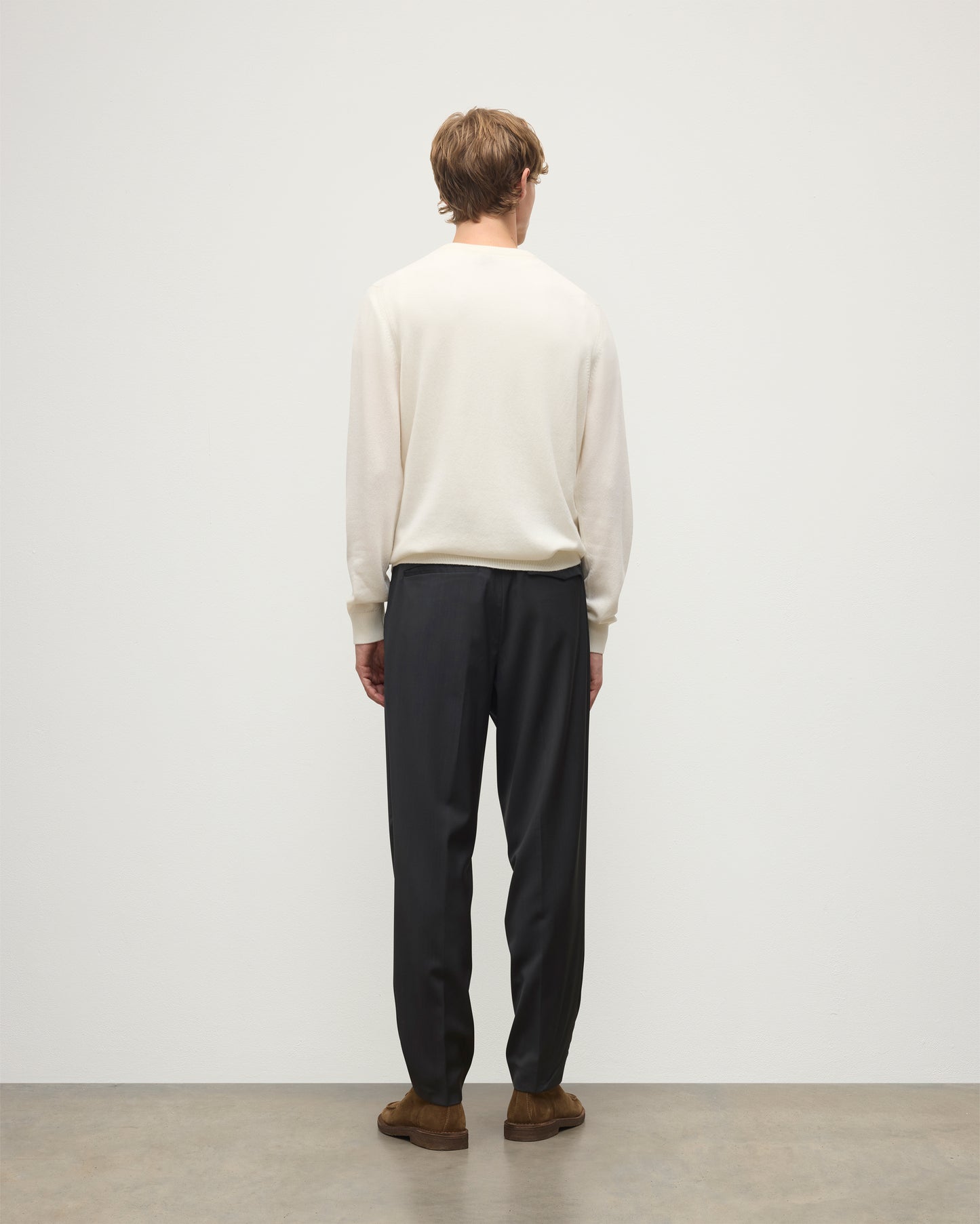MODEL WEARS JOHNSTONS OF ELGIN MENS RORY CREW CLASSIC JUMPER WHITE 100% CASHMERE WITH GREY TROUSERS AND BROWN BELT AND SHOES KAP05471SA0606