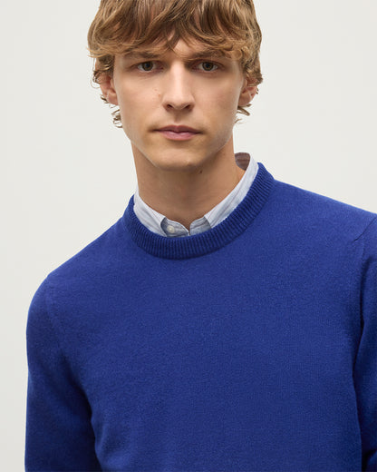 MODEL WEARS JOHNSTONS OF ELGIN MENS RORY CREW CLASSIC JUMPER BLUE 100% CASHMERE OVER A LIGHT BLUE SHIRT KAP05471SD5326