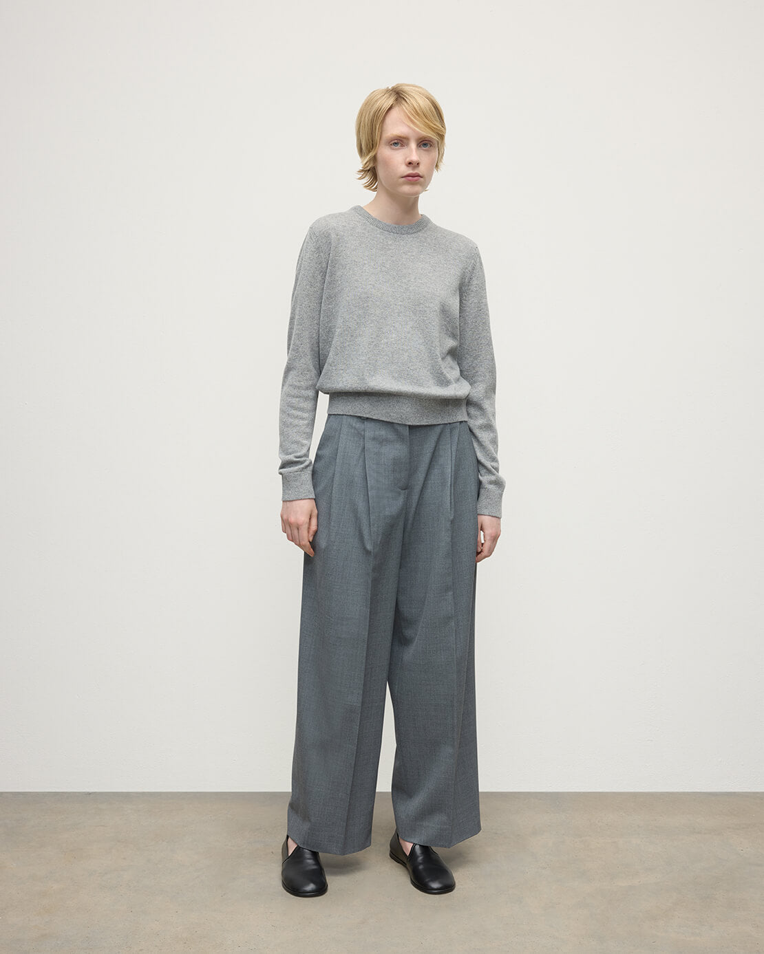 Model wears Johnstons of Elgin AW25 Women's Knitwear Light Grey Classic Cashmere Grey Round Neck Jumper Front KAP05572HA0308