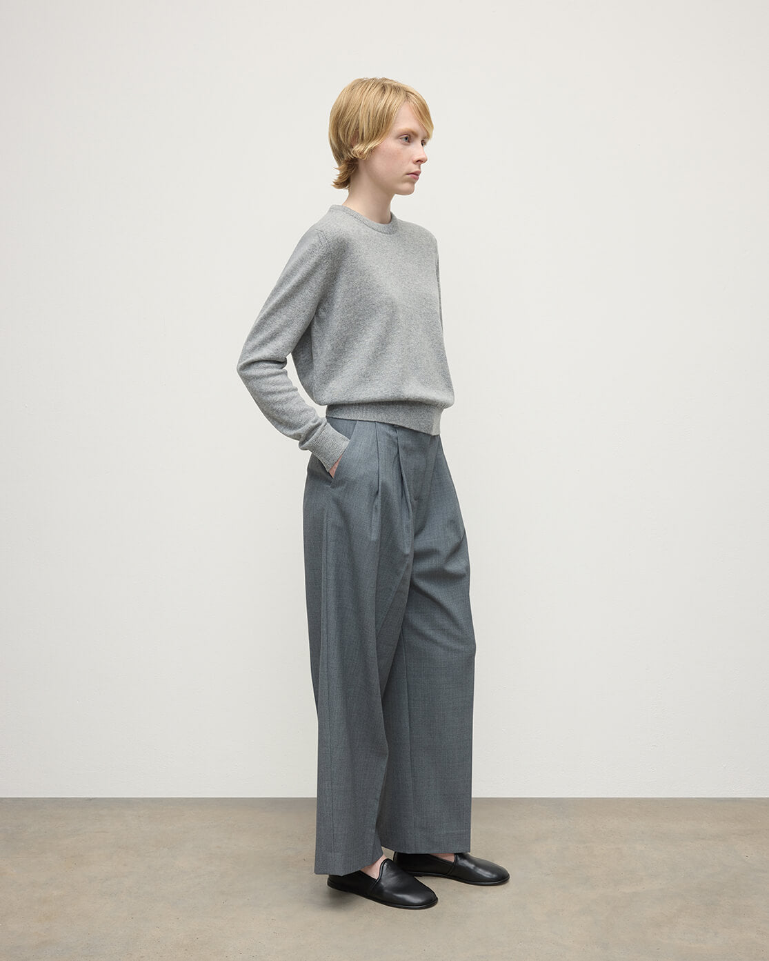Model wears Johnstons of Elgin AW25 Women's Knitwear Light Grey Classic Cashmere Grey Round Neck Jumper Side KAP05572HA0308