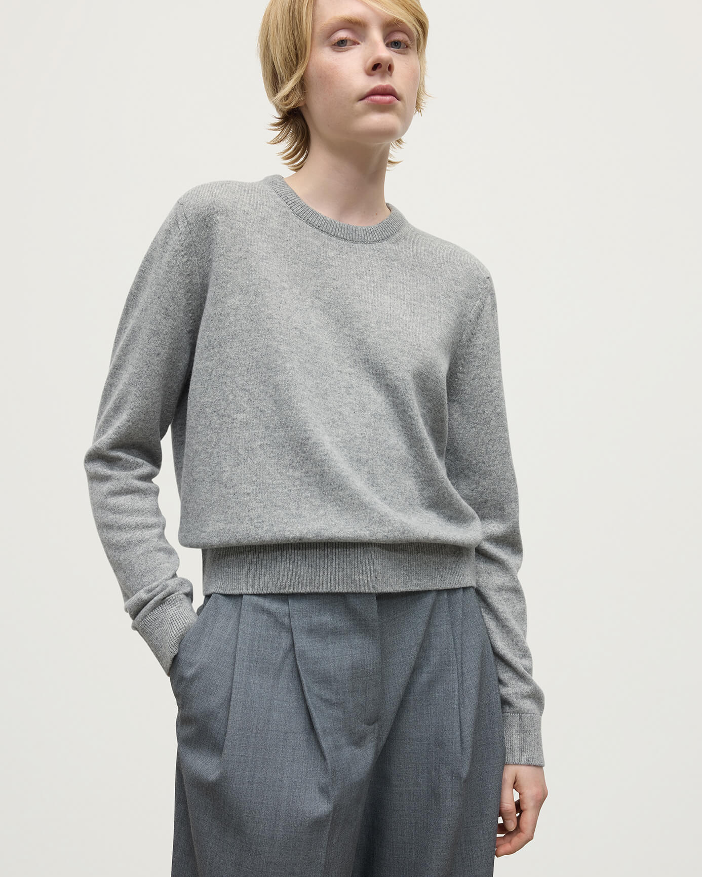 Model wears Johnstons of Elgin AW25 Women's Knitwear Light Grey Classic Cashmere Grey Round Neck Jumper Close Up KAP05572HA0308