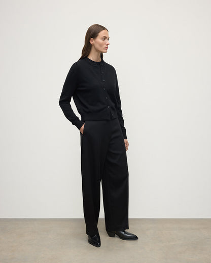 Model wears Johnstons of Elgin AW25 Women's Knitwear Black Classic Cashmere Black Cardigan Side KAP05573SA7210