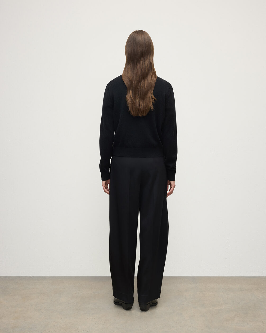 Model wears Johnstons of Elgin AW25 Women's Knitwear Black Classic Cashmere Black Cardigan Back KAP05573SA7210