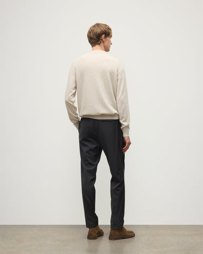 MODEL WEARS JOHNSTONS OF ELGIN MENS RORY VEE NECK CLASSIC JUMPER NATURAL 100% CASHMERE, OVER A WHITE T-SHIRT WITH NAVY TROUSERS  KAP05594HA0402