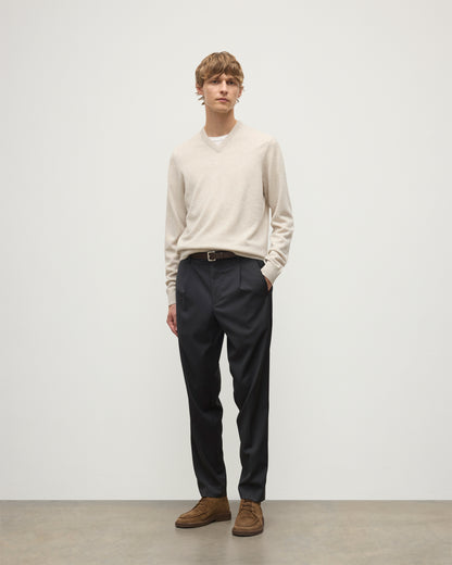 MODEL WEARS JOHNSTONS OF ELGIN MENS RORY VEE NECK CLASSIC JUMPER NATURAL 100% CASHMERE, OVER A WHITE T-SHIRT WITH NAVY TROUSERS  KAP05594HA0402