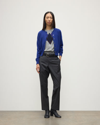 MODEL WEARING JOHNSTONS OF ELGIN WOMENS IRIS CLASSIC CREW CARDIGAN BLUE 100% CASHMERE OVER LE JABOT CASHMERE TANK WITH GREY TROUSERS AND BLACK BOOTS KAP05704SD5326