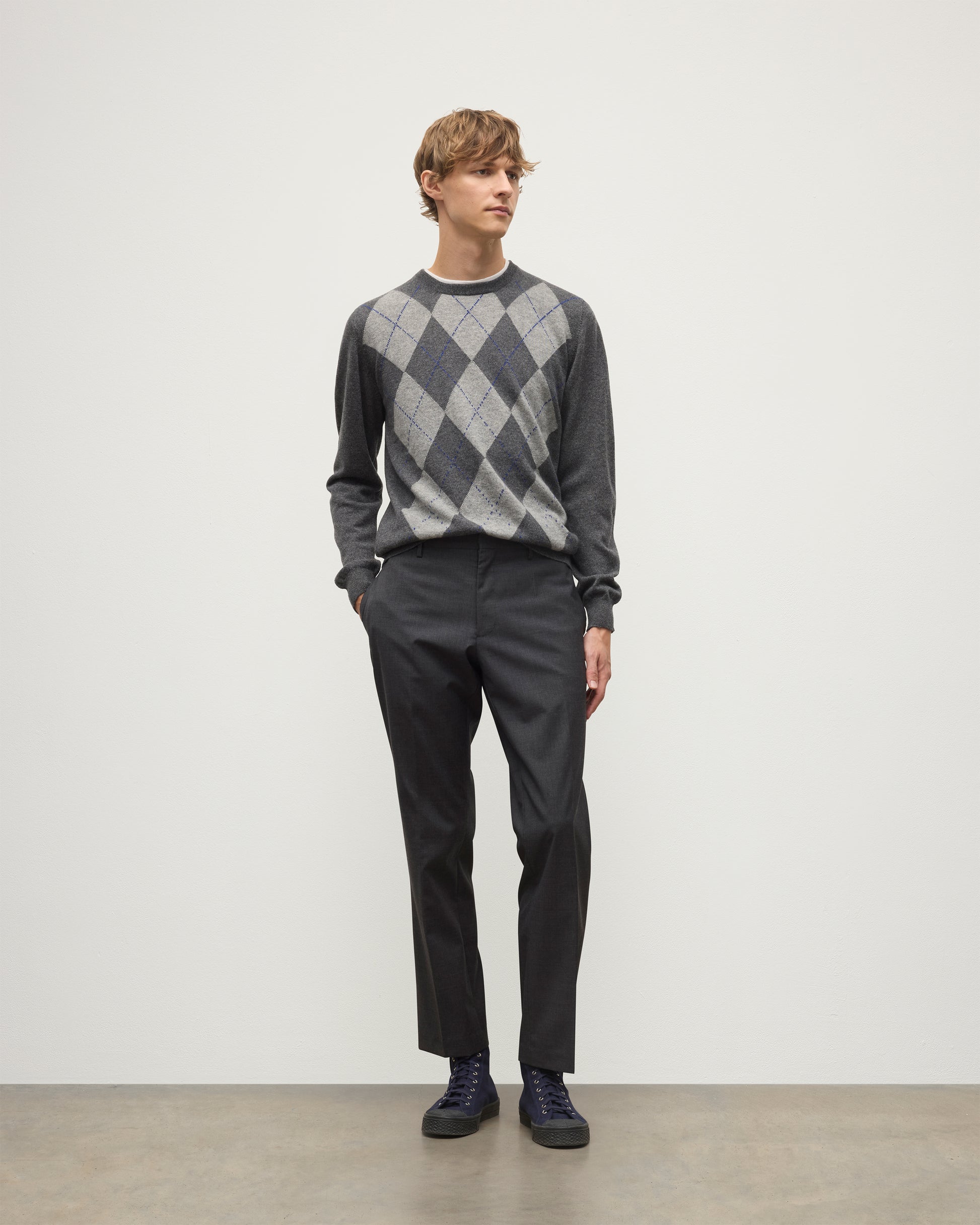MODEL WEARS JOHNSTONS OF ELGIN MENS ARGYLL CREW SWEATER GREY & BROWN 100% CASHMERE WITH GREY TROUSERS KAP05747JU1601