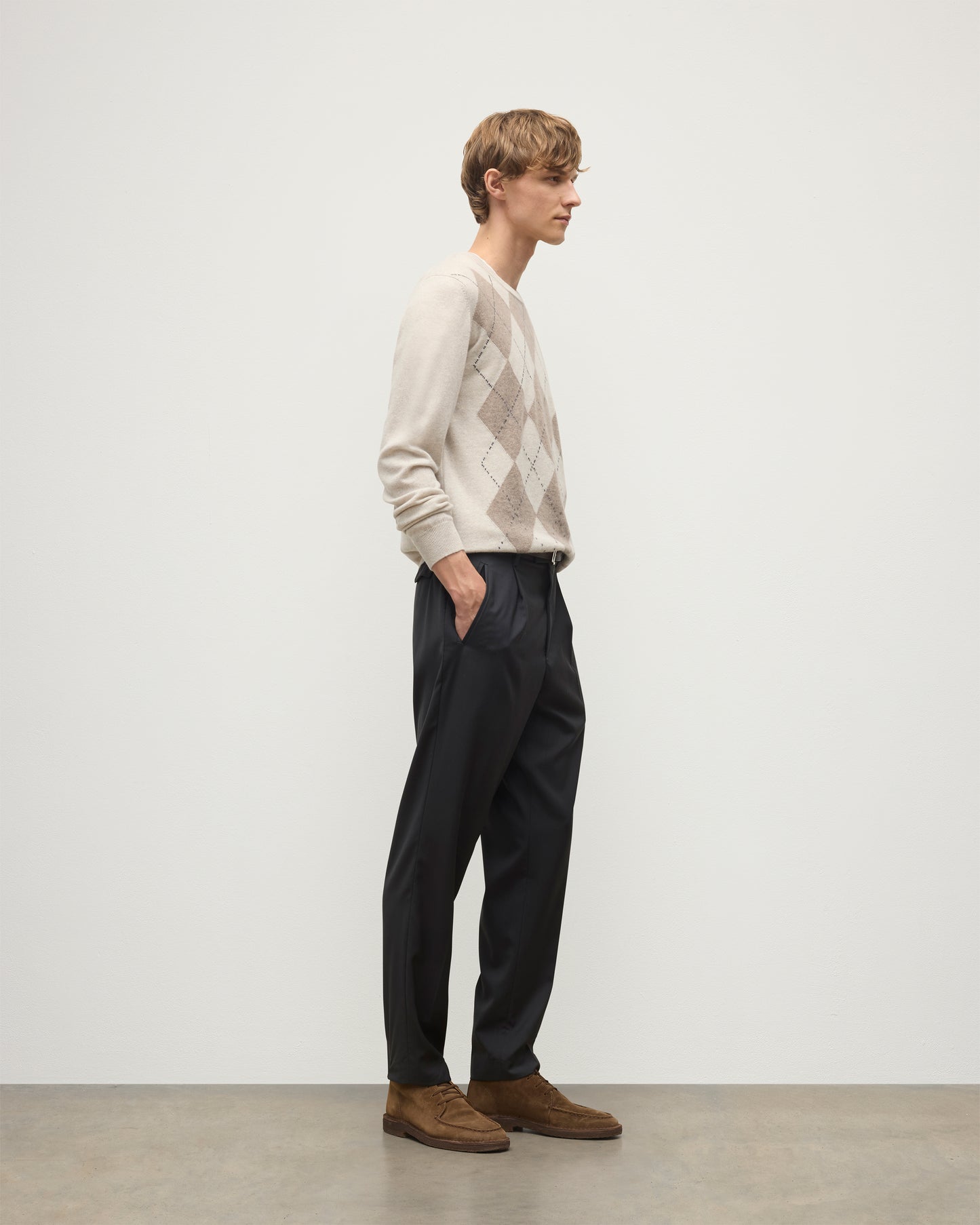 MODEL WEARS JOHNSTONS OF ELGIN MENS ARGYLL CREW SWEATER NATURAL 100% CASHMERE WITH NAVY TROUSERS KAP05747JU1602