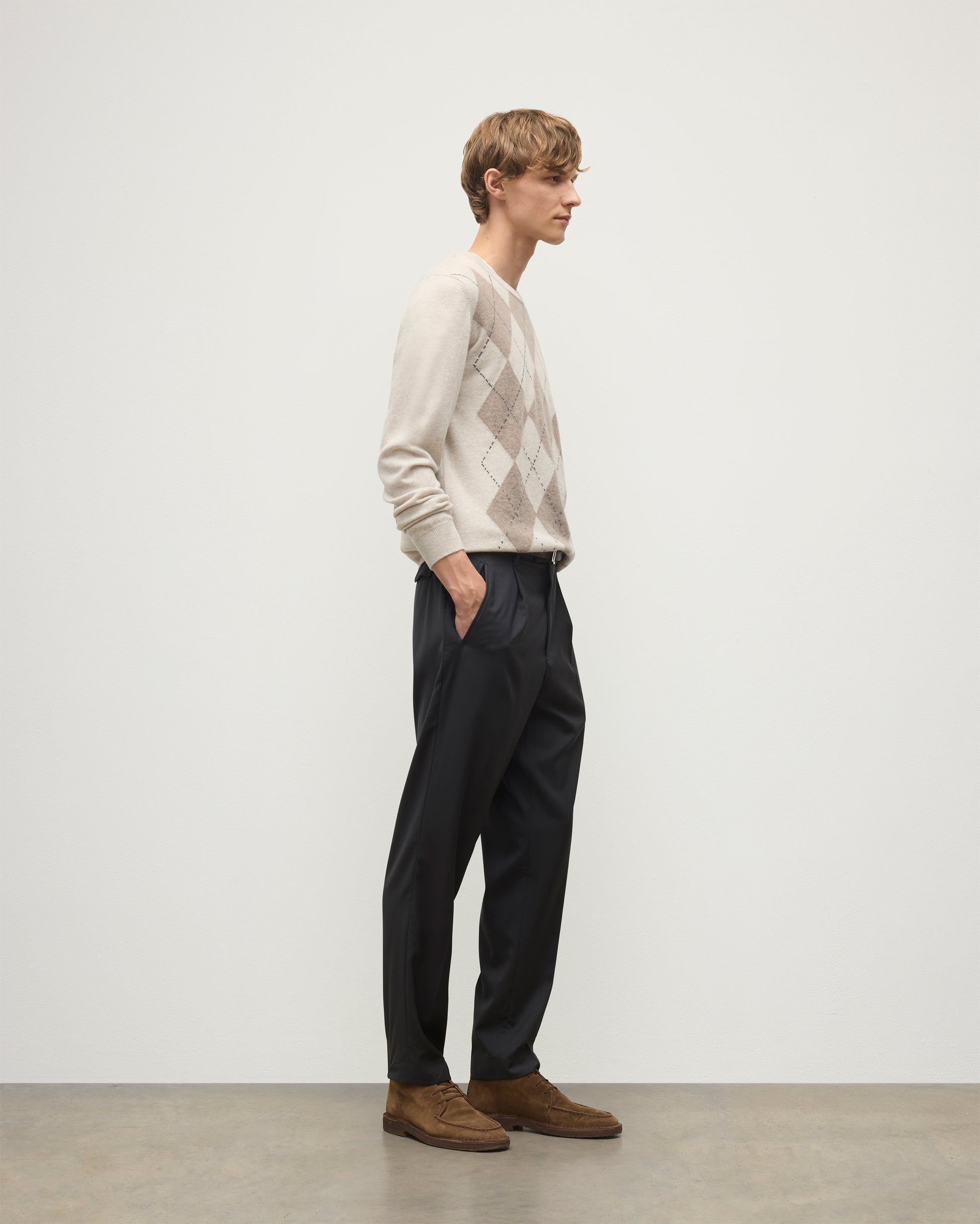 MODEL WEARS JOHNSTONS OF ELGIN MENS ARGYLL CREW SWEATER NATURAL 100% CASHMERE WITH NAVY TROUSERS KAP05747JU1602