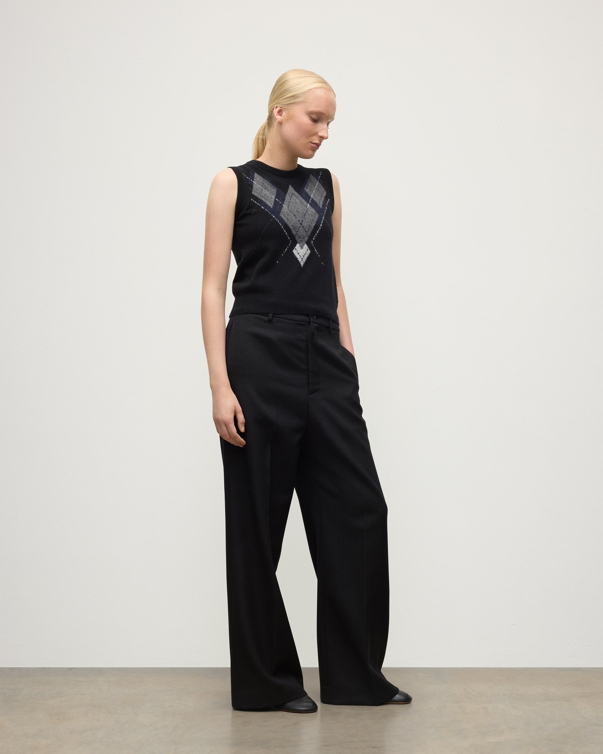 MODEL WEARING JOHNSTONS OF ELGIN WOMENS ARGYLL LE JABOTS SLEEVELESS CREW BLACK 100% CASHMERE WITH BLACK TROUSERS KAP05766JU1609