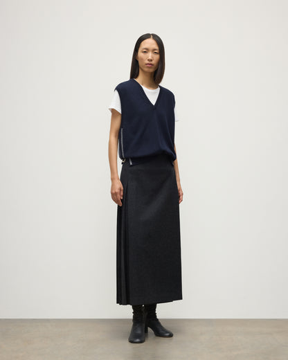 MODEL WEARS JOHYNSTONS OF ELGIN WOMENS TILDA SLEEVELESS VEE NAVY 100% CASHMERE WITH LE KILT JOHNSTONS OF ELGIN CASHMERE KILT IN CHARCOAL KAP05767Q25968