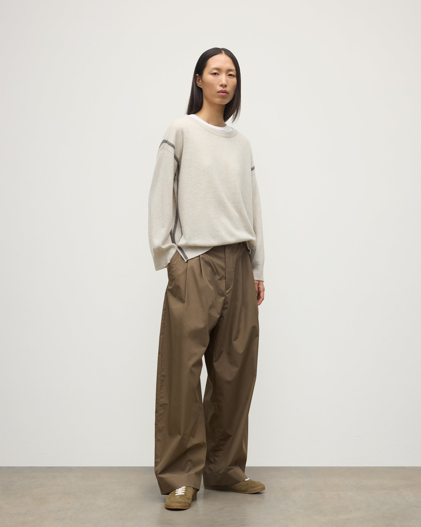 MODEL WEARS JOHNSTONS OF ELGIN WOMENS TILDA CREW SWEATER NATURAL OVER A WHITE T-SHIRT, WITH BROWN TROUSERS KAP05768Q25972