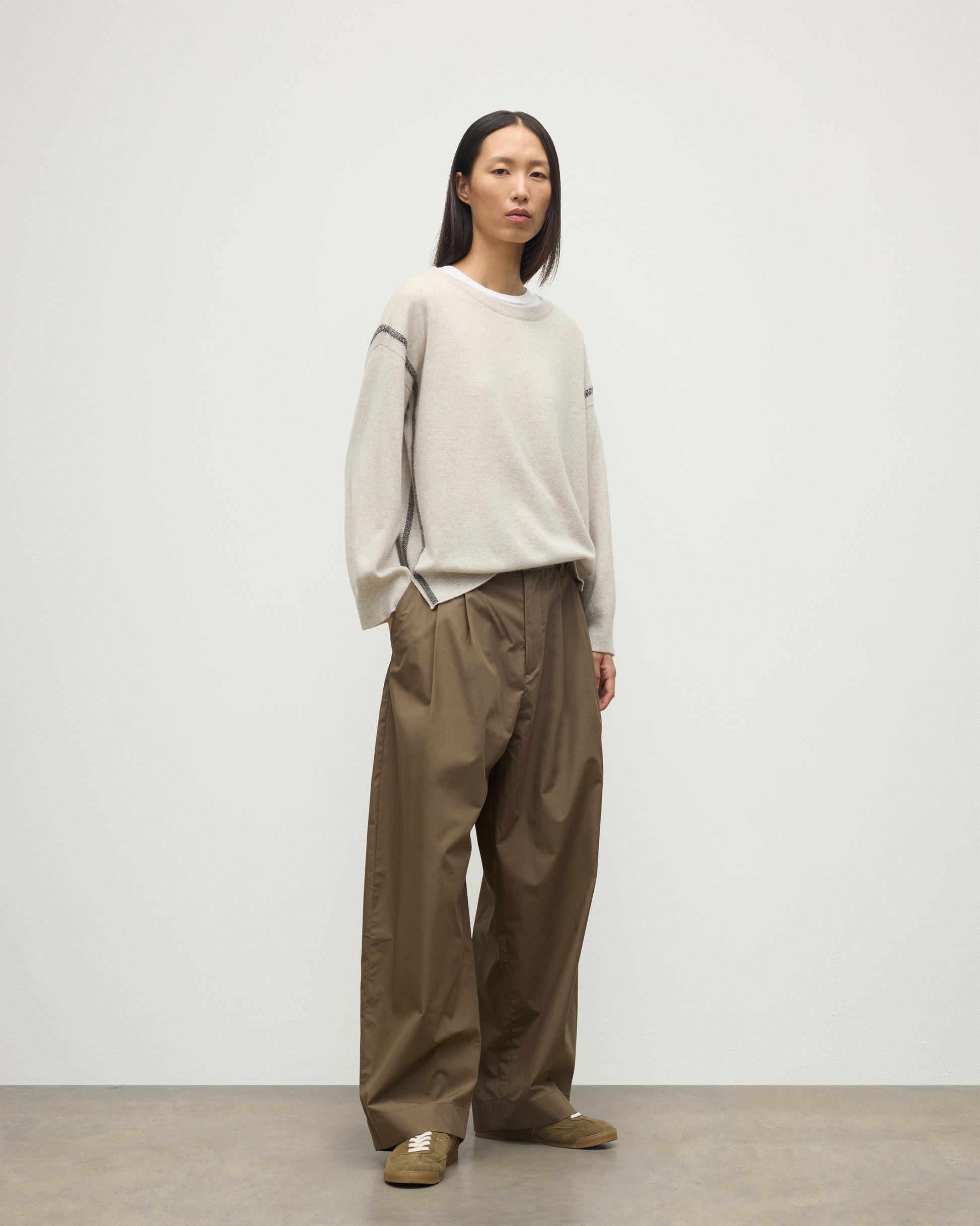 MODEL WEARS JOHNSTONS OF ELGIN WOMENS TILDA CREW SWEATER NATURAL OVER A WHITE T-SHIRT, WITH BROWN TROUSERS KAP05768Q25972