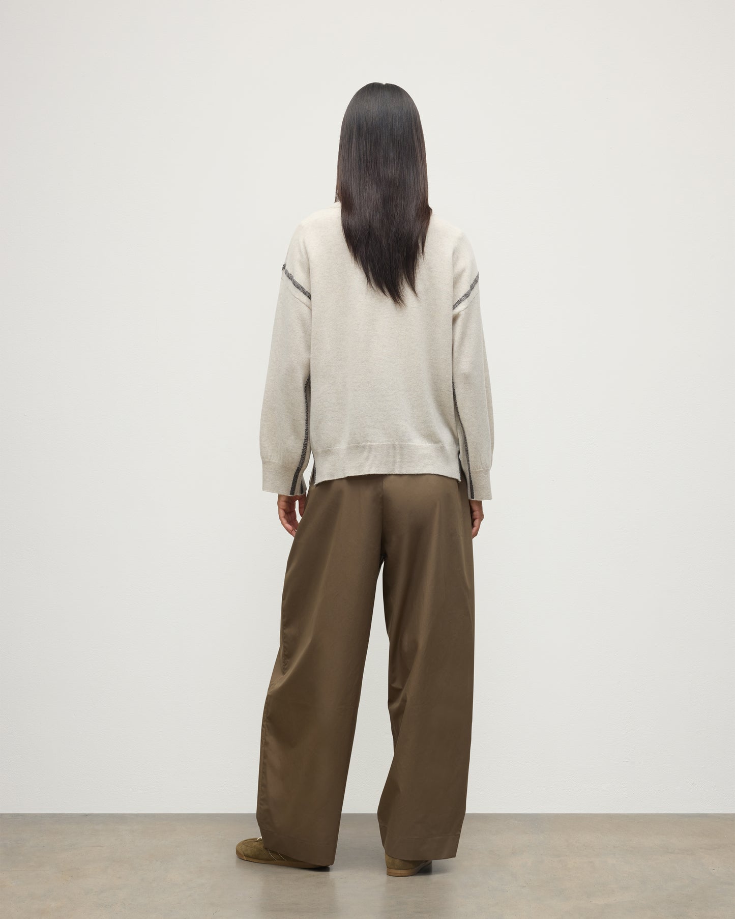 MODEL WEARS JOHNSTONS OF ELGIN WOMENS TILDA CREW SWEATER NATURAL OVER A WHITE T-SHIRT, WITH BROWN TROUSERS KAP05768Q25972