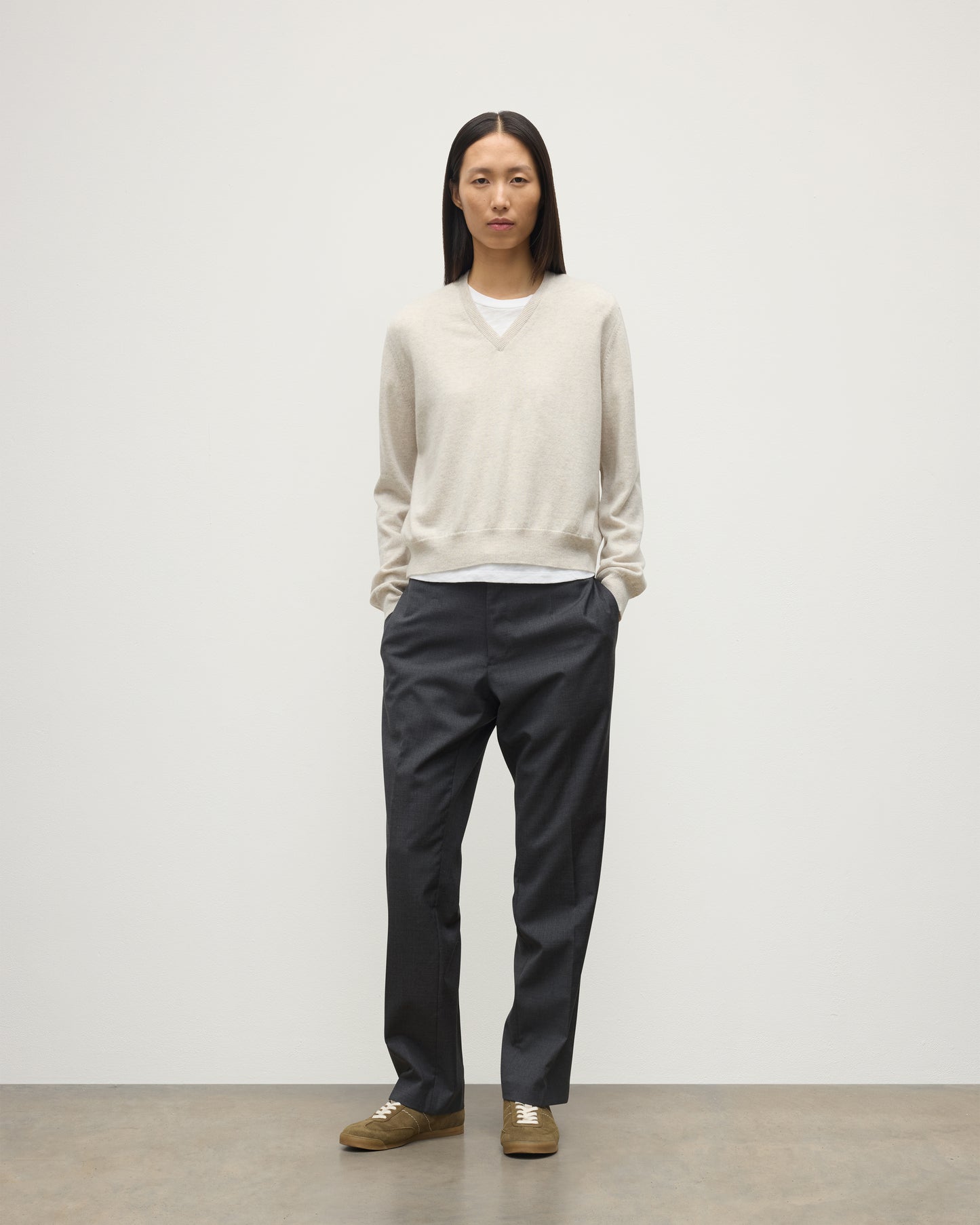 MODEL WEARING JOHNSTONS OF ELGIN WOMENS LUNAN CLASSIC VEE SWEATER NATURAL 100% CASHMERE WITH NAVY TROUSERS KAP05807HA0402