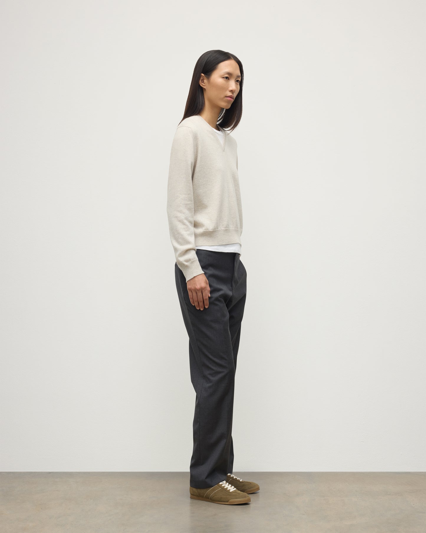 MODEL WEARING JOHNSTONS OF ELGIN WOMENS LUNAN CLASSIC VEE SWEATER NATURAL 100% CASHMERE WITH NAVY TROUSERS KAP05807HA0402