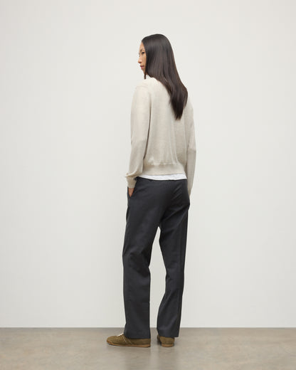 MODEL WEARING JOHNSTONS OF ELGIN WOMENS LUNAN CLASSIC VEE SWEATER NATURAL 100% CASHMERE WITH NAVY TROUSERS KAP05807HA0402