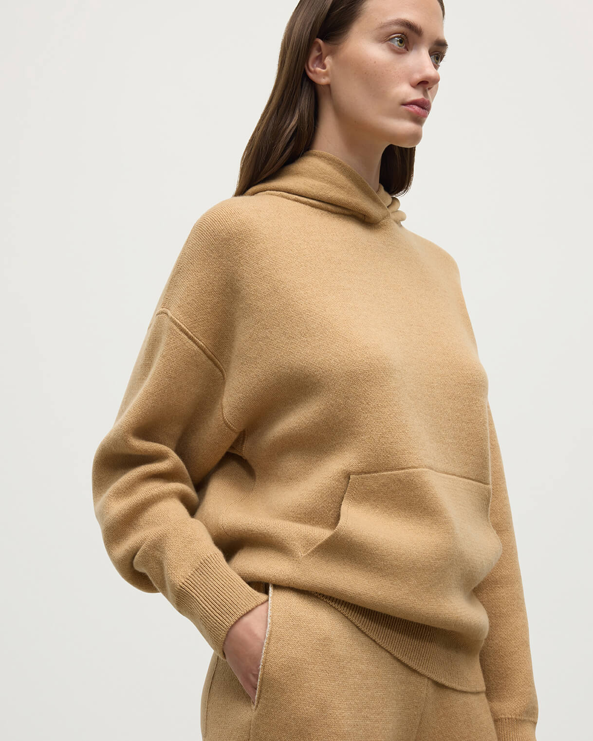 Model wears Johnstons of Elgin AW25 Women's Knitwear Camel & Natural Double-Face Camel Cashmere Hoodie details KBA01034Q25325