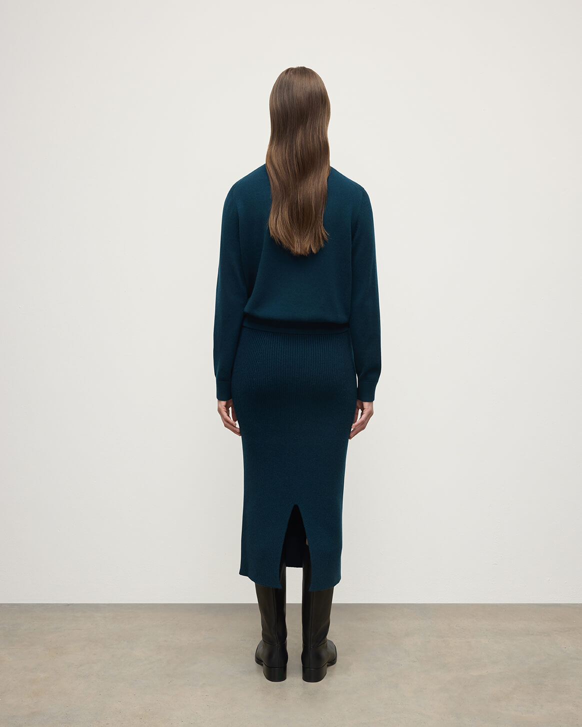 model wears Johnstons of Elgin AW25 Women's Knitwear Bottle Green Cashmere Green Midi Skirt Back View KBC01032SC7341