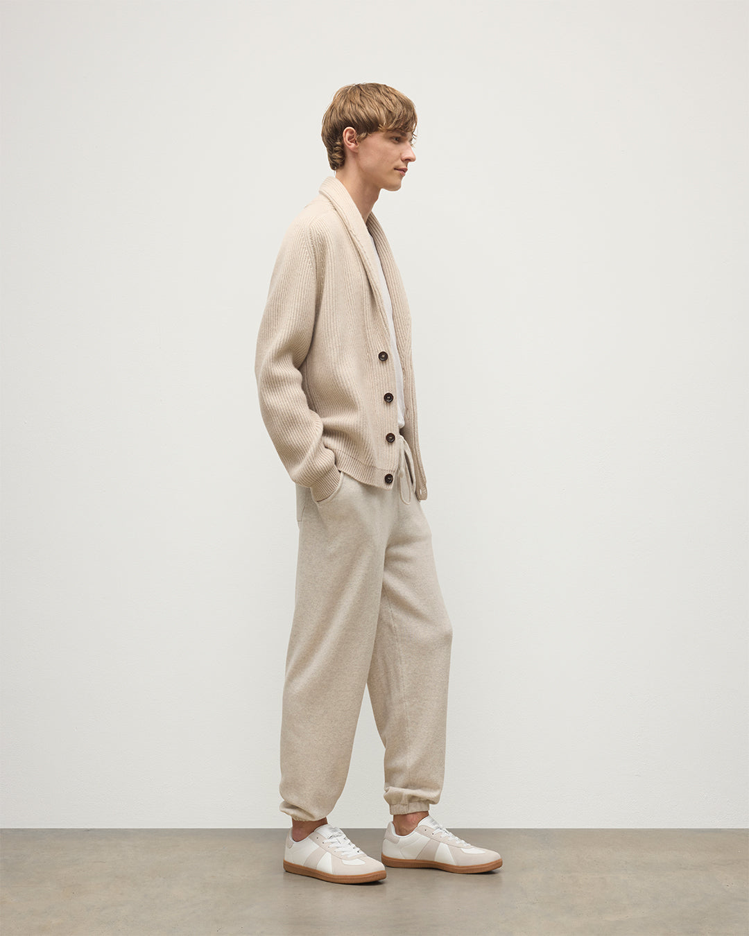 MODEL WEARING JOHNSTONS OF ELGIN MENS KIRK SWEATPANTS NATURAL 97% CASHMERE 3% POLYESTER WITH A WHITE T-SHIRT AND PIONEER CASHMERE CARDIGNA IN NATURAL KBP00948HA0402