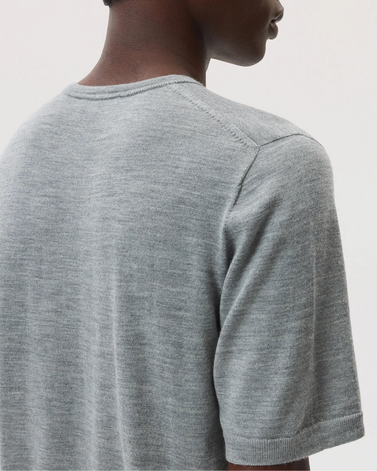 Model wears Johnstons of Elgin SS25 Men's Knitwear Light Grey Superfine Merino T-Shirt KDI00663HA4183