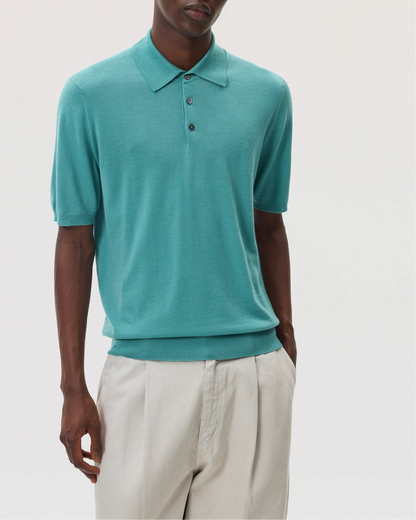 Model wearing Johnstons of Elgin SS25 Men's Knitwear Jade Superfine Merino Polo Shirt with beige chinos  KDI00715SC4641