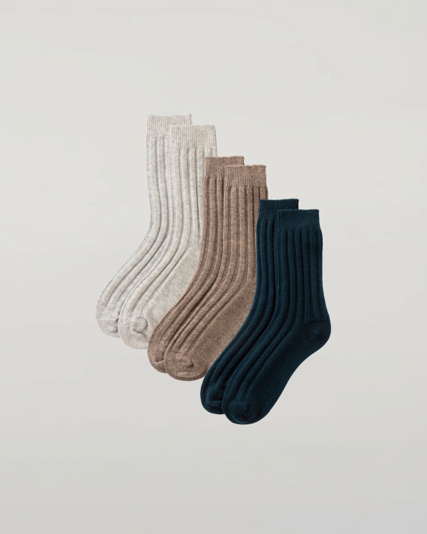 Johnstons of Elgin set of three pairs of cashmere socks in grey, beige, and green on a light grey background 2025GIFTSET4B