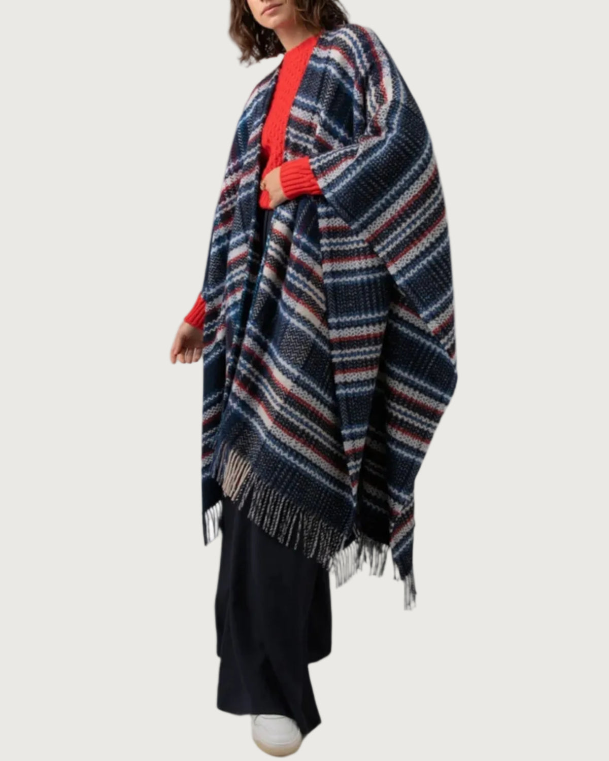 Johnstons of Elgin Cashmere Wool Blend Textured Donegal Cape Navy Multi worn over an Orkney Red Cable Sweater and Navy Trousers on a grey background TB000632RU7354ONE