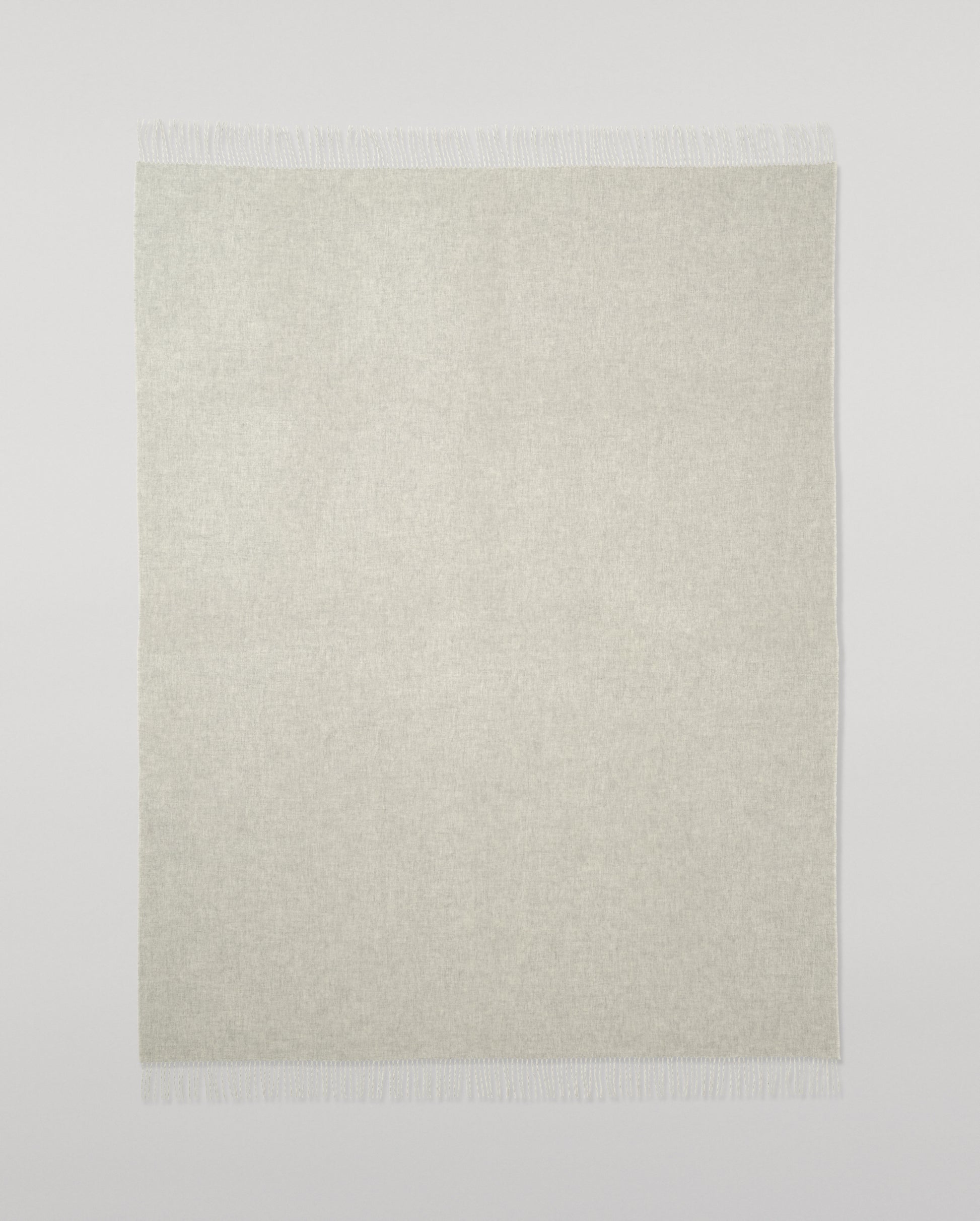 Johnstons of Elgin Light Grey & White reversible blanket on a grey background WA000013RU5059ONE