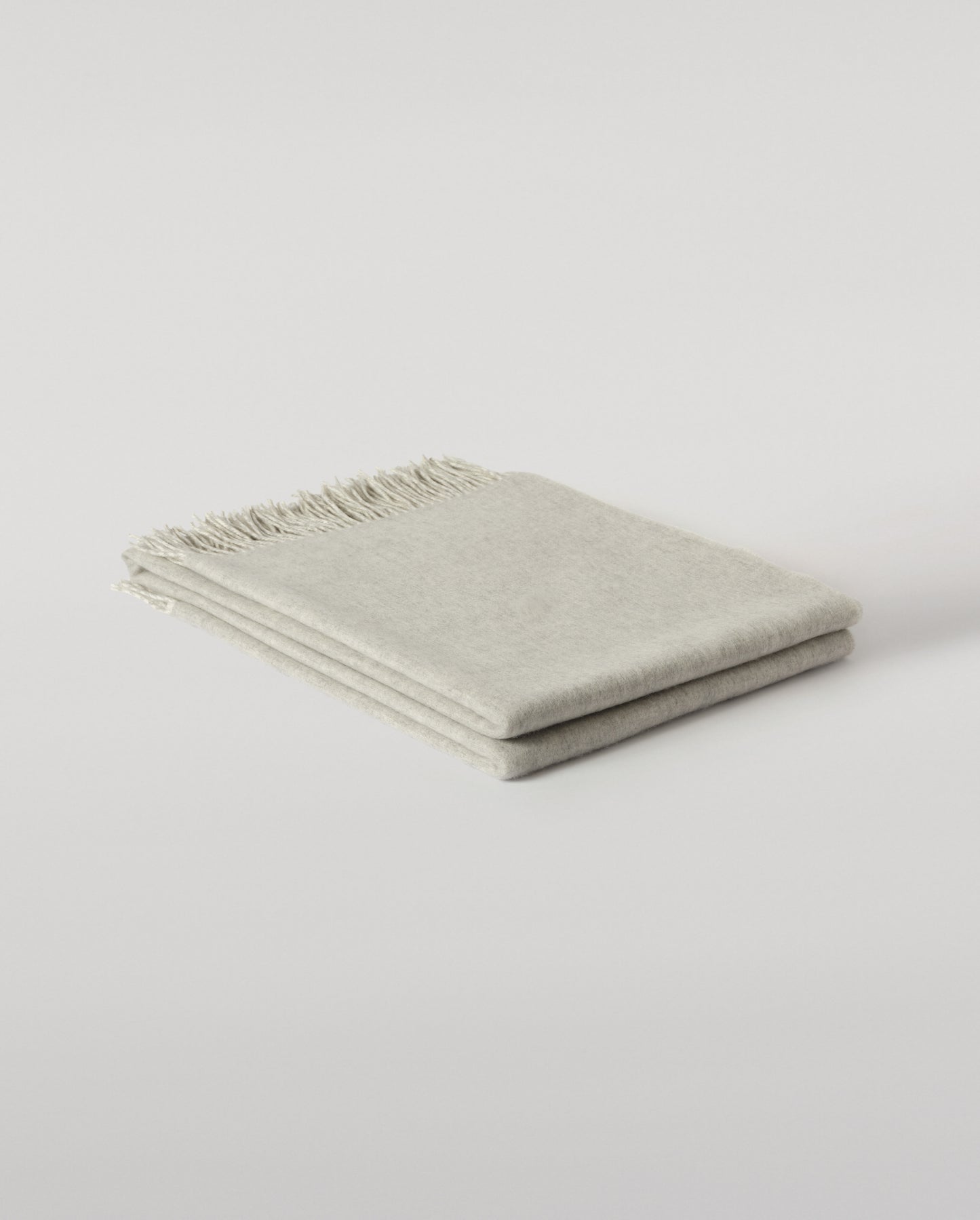 Johnstons of Elgin Light Grey & White reversible blanket on a grey background WA000013RU5059ONE