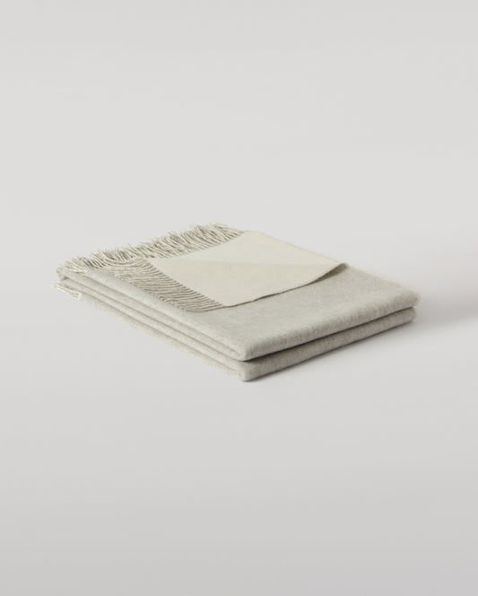 Johnstons of Elgin Light Grey & White reversible blanket on a grey background WA000013RU5059ONE
