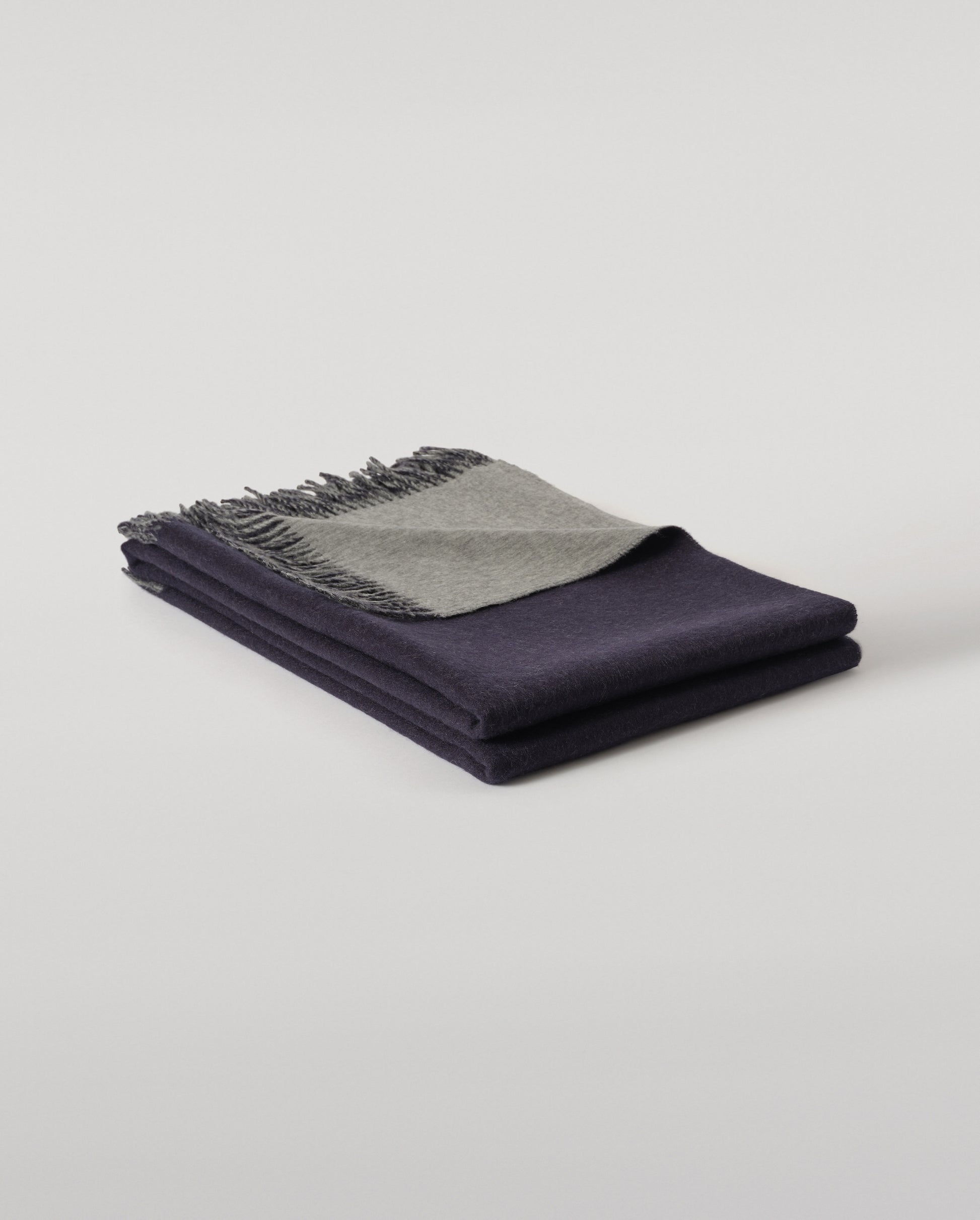 Johnstons of Elgin Interiors Collection  Reversible Navy & Light Grey Cashmere Throw on a wooden chair  WA000013RU6632N/A