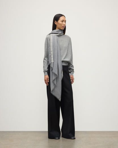 MODEL WEARS JOHNSTON OF ELGIN IVES CHEVRON BORDER SCARF 100% CASHMERE OVER A LIGHT GREY CASHMERE SWEATER WA002446RU7700ONE