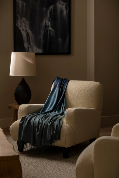 2025 Johnstons of Elgin Interiors Collection Seascape & Navy Ombré Cashmere Throw draped on a chair in a neutrally decorated room  WA000055RU7686ONE