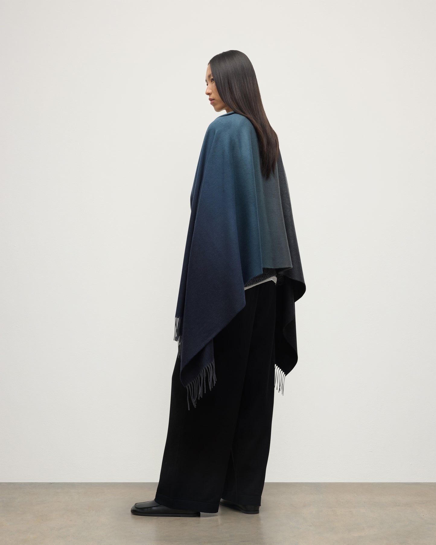 FEMALE MODEL WEARING JOHNSTONS OF ELGIN UMBRA OMBRE STOLE BLACK & NAVY 100% CASHMERE OVER BLACK CASHMERE KNITWEAR WA000056RU7302ONE