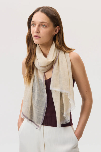 Female model wearing Johnstons of Elgin SS25 Accessories Natural Colour Border Lightweight Scarf over our rosewood superfine cashmere vest top, on a white background WB002693RU7595ONE