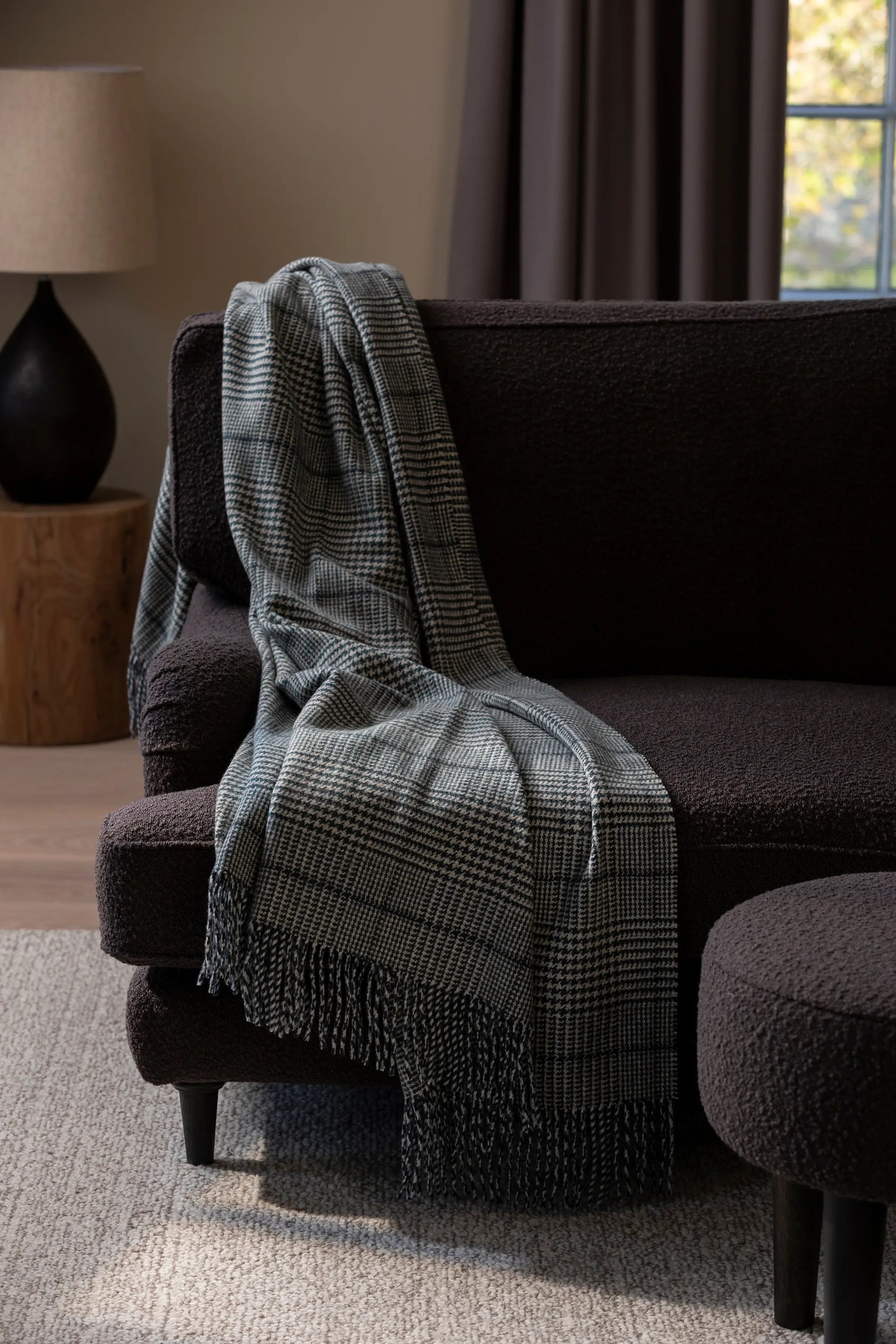 2025 Johnstons of Elgin Interiors Collection Bottle Tweed Glen Check Wool Throw on a dark brown couch in a sitting room WDC01930RU7652ONE